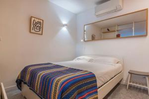 una piccola camera da letto con un letto e uno specchio di Modern & Hidden Apartment by LovelyStay a Lisbona