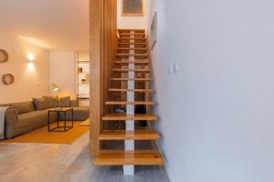 una scala a chiocciola in un soggiorno con divano di Modern & Hidden Apartment by LovelyStay a Lisbona