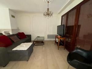 a living room with a couch and a tv at Spacieuse maison pour 6 à 8 personnes in Noisy-le-Sec