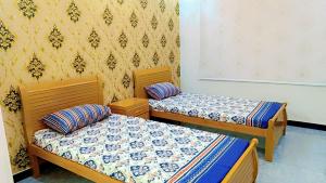 ein Zimmer mit zwei Betten und einer Wand in der Unterkunft Hotel in Islamabad Luxurious 2 Bedroom in Islamabad