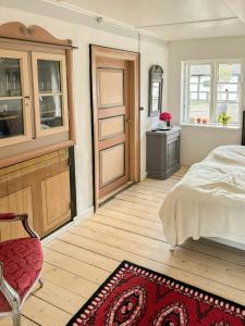 1 dormitorio con cama, puerta y alfombra en Historic Skipper Farm Near Nordby Hills And Beach, en Nordby