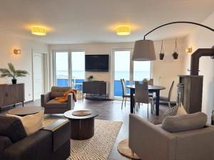 Meerblickappartement mit Kamin في ساسنيتز: غرفة معيشة بها أريكة وطاولة