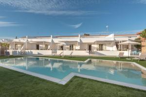 a large swimming pool in front of a house at Blu Mediterraneo - IsulaTravel in Ispica
