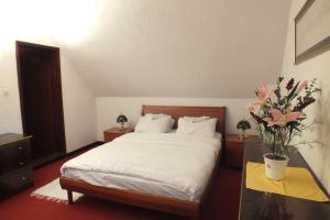 a bedroom with a bed and flowers on a table at ApartHotel Kopaonik in Brzeće