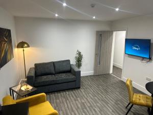 a living room with a couch and a flat screen tv at Delightful 2-Bedroom Flat Perfect for City Adventurers in Long Eaton