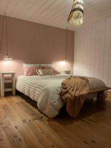 a bedroom with a large bed with a wooden floor at Au Chalet Bourguignon 4 in Salives