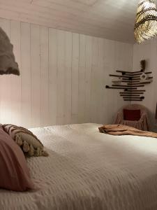 a bedroom with a large white bed and a chandelier at Au Chalet Bourguignon 4 in Salives