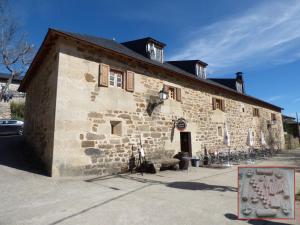 an old stone building with a sign in front of it at La Posada de Pedrazales in Pedrazales