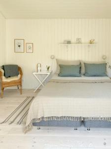 a bedroom with a large bed and a chair at Cozy Summer House Close To Bisnap Beach in Hals
