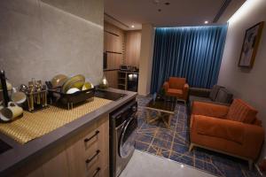 a kitchen with a sink and a living room at Seagull Serviced Apartments in Jeddah