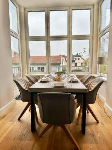 a dining room with a table and chairs and windows at Traumhaftes Apartment mit gratis Parkplatz und Balkon G3 in Oldenburg