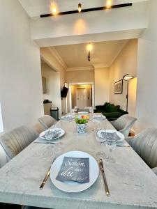 a dining table with glasses and plates on it at Traumhaftes Apartment mit gratis Parkplatz und Balkon G3 in Oldenburg +17 photos
