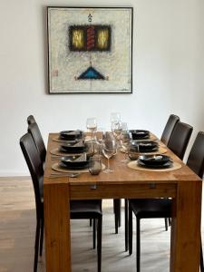 a dining room table with wine glasses and a painting at Ferienwohnung Norderstedt in Norderstedt +10 photos