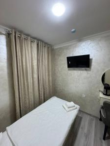 a bedroom with a bed and a tv on the wall at Sumaya Hotel in Tashkent +24 photos