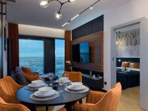 a dining room and living room with a table and chairs at URBAN APARTMENTS GLOBAL SKYLINE, 21st Floor No 19, Free Garage, Self Check-in, No Deposit in Katowice