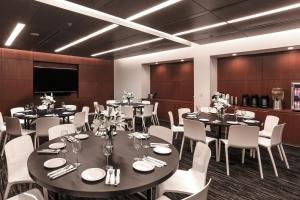 a conference room with tables and white chairs at Courtyard by Marriott Long Island City/New York Manhattan View in Queens