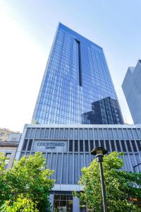 a tall building with a sign on the side of it at Courtyard by Marriott Long Island City/New York Manhattan View in Queens