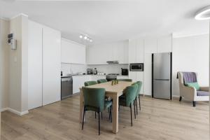 a kitchen and dining room with a table and chairs at ZenDen Destinations' Seaside Sanctuary Suite in Strand