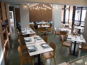 a dining room with white tables and chairs at Sunflower Hotel Apartments in Larnaca