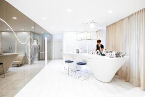 uma mulher parada num balcão branco num quarto em VISIONAPARTMENTS Vevey - contactless check-in em Vevey