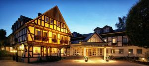 a large building with its lights on at night at Romantikhotel Platte in Attendorn