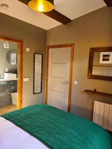 a bedroom with a large bed with a green comforter at The Hide in Ullapool