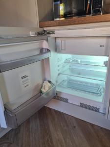 an empty refrigerator with its door open in a kitchen at The Hide in Ullapool