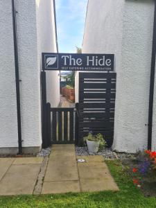 a building with a sign that reads the hide at The Hide in Ullapool