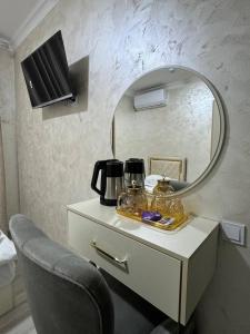 a dressing table with a mirror and a chair at Sumaya Hotel in Tashkent