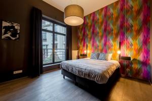 sypialnia z łóżkiem z kolorową ścianą w obiekcie Smartflats Design - Schuman w Brukseli