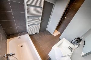 a bathroom with a tub and a toilet and a sink at Smartflats Design - Schuman in Brussels