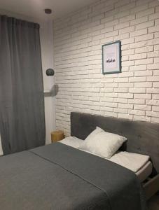Un dormitorio con una cama y una pared de ladrillo. en Zielony Tarchomin, en Varsovia
