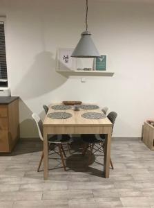 Una mesa y sillas en una cocina con luz auxiliar. en Zielony Tarchomin, en Varsovia