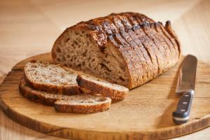a loaf of bread on a cutting board with a knife at Yarn - Arlo Deluxe Suite in Ballycastle +7 photos