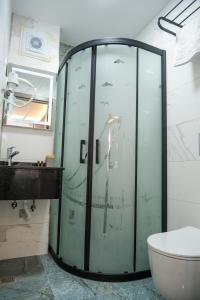 a glass shower in a bathroom with a sink and a toilet at mansion yellow hotel in Istanbul