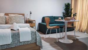 Un dormitorio con una cama, una mesa y un sofá. en Alojamientos Rurales Las Candelas, en Santa Marta de Magasca