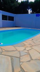 a swimming pool with blue water in a backyard at Recanto Dos Vargas in Florianópolis