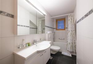 a white bathroom with a sink and a toilet at Chalet Sterndolde Apt 1 in Wengen