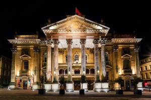 a large building with columns at night at The County Hotel Newcastle in Newcastle upon Tyne