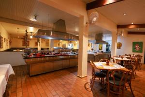 a kitchen and dining room with a table and chairs at Hotel Berro D`Agua Eco Resort in Avaré