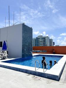 a group of people in a swimming pool at I-17 um Studio aconchegante in Maceió