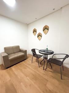 a living room with a couch and a table and chairs at I-17 um Studio aconchegante in Maceió +17 photos