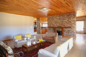 Una sala de estar con sofás y chimenea. en Geluk Farmhouse, en Somerset East