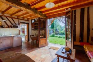 un grand salon avec une cuisine et une table dans l'établissement Gîte Le Capricorne avec grande piscine Au cœur du Lot-et-Garonne, à Lavergne