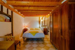 une chambre avec un lit et un plafond en bois dans l'établissement Gîte Le Capricorne avec grande piscine Au cœur du Lot-et-Garonne, à Lavergne 14 autres photos