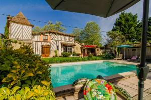 une piscine devant une maison dans l'établissement Gîte Le Capricorne avec grande piscine Au cœur du Lot-et-Garonne, à Lavergne