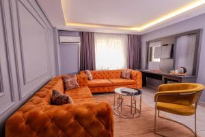 un soggiorno con un divano arancione e un tavolo di Ruby Hotel a Istanbul