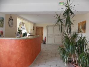 a lobby with two palm trees in a room at Au Relais Provencal in Bagnols-en-Forêt
