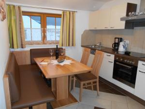 a small kitchen with a wooden table and chairs at Pöllitzer Hollnhof in Tamsweg