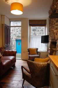 a living room with a couch and chairs and a tv at Cysgod Idris Cottage in Dolgellau